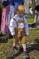 A young boy is dressed in traditional lederhosen during the Maibaumfest in Putzbrunn, Germany.