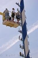 The aid of a crane is needed to hang this Company sign on the Maibaum in Putzbrunn, Southern Bavaria.