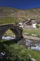 An ancient stone bridge crosses over the Riu Escrita into the village of Espot in Catalonia, Spain.