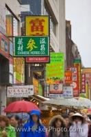 The street of Chinatown in Toronto, Ontario is full of people who love shopping even on a rainy day when umbrellas are required.