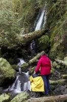 A couple enjoys a moment of relaxation at one of the waterfalls in the Olympic National Park of Washington, USA.