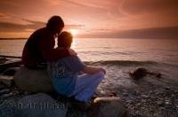 A couple watch the sunset during a romantic getaway at Simcoe Lake in Ontario, Canada.