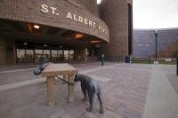 A cute bronze sculpture of a boy and dog outside the City Hall Building in St Albert, Alberta, Canada.