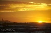 The bright golden sun sinks below the horizon at Ruby Beach on the Olympic Peninsula of Washington, USA.