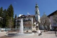 The fountain in the town square of Toblach in South Tyrol, Italy is surrounded by extraordinary buildings.
