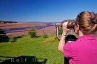 A tourist uses binoculars to get a good close-up view of the Minas Basin in the town of Walton off Highway 215 in the Fundy Shore Ecotour. This is along the Glooscap Trail near the Minas Basin in Cobequid Bay, Nova Scotia.