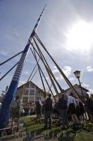 A pole is used to stand the traditional Maibaum in place during the Maibaumfest in the European village of Putzbrunn, Germany.
