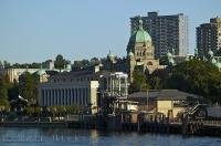 A mix of historic and modern buildings line the inner harbour in the city of Victoria, BC, Canada.