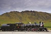 The shiny black and brass engine of the Kingston Flyer, a vintage steam train, idles pending departure from the Fairlight Station in Central Otago, NZ.