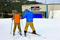 At this Whistler Mountain Ski School in British Columbia, a ski instructor teaches and helps a student with their ski skills. Whistler is known as a first-class destination for skiing and winter sports and is soon to co-host the Olympics.