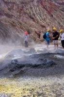 Passengers who boarded the boat tour to White Island, New Zealand enjoy the opportunity of standing around large volcanic openings found in the landscape.